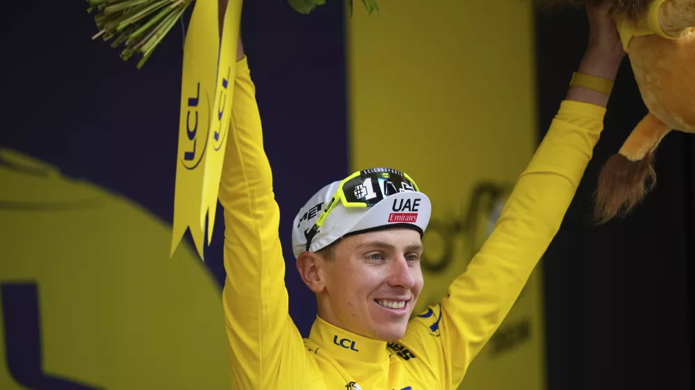 Slovenia's Tadej Pogacar, wearing the overall leader's yellow jersey, celebrates on the podium after during the nineteenth stage of the Tour de France cycling race over 144.6 kilometers (89.9 miles) with start in Embrun and finish in Isola 2000, France, Friday, July 19, 2024. (AP Photo/Daniel Cole)