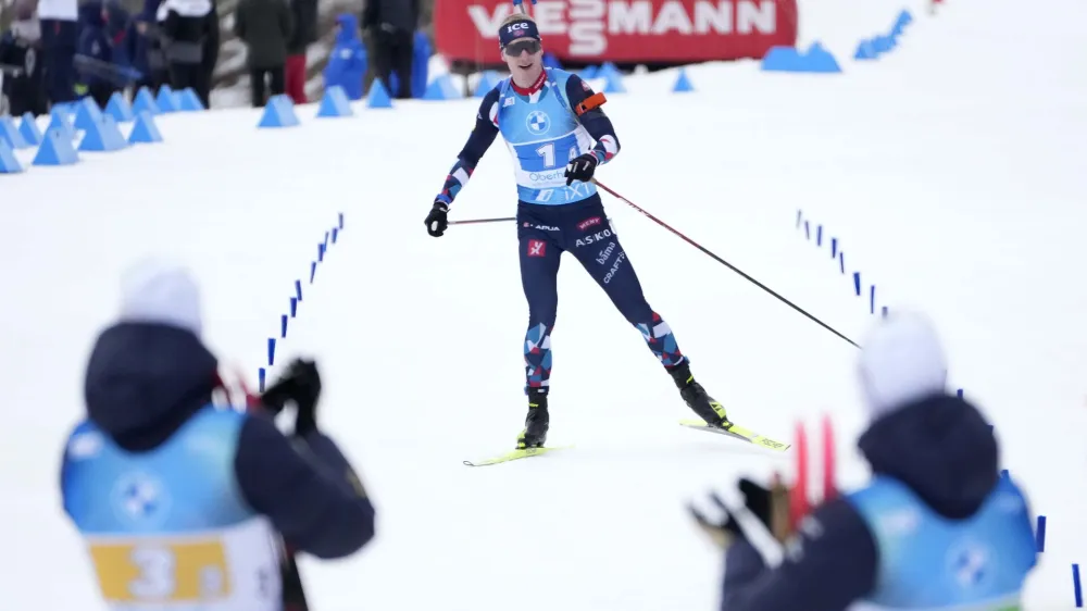 French Athletes in the foreground applaud as Johannes Thingnes Boe, of Norway, approaches the finish line to win the silver medal in the Men 4 X 7.5 km Relay event at the Biathlon World Championships in Oberhof, Germany, Saturday, Feb. 18, 2023. (AP Photo/Matthias Schrader)