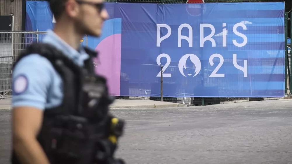 FILE - A police officer walks past a Paris Olympics canvas at the 2024 Summer Olympics, Saturday, July 20, 2024, in Paris, France. Three days before the start of the Olympics, France's Interior Minister has hailed the country's law enforcement for their hard work in making the Paris Games safe for 10,500 athletes and millions of visitors. (AP Photo/Thomas Padilla, File)