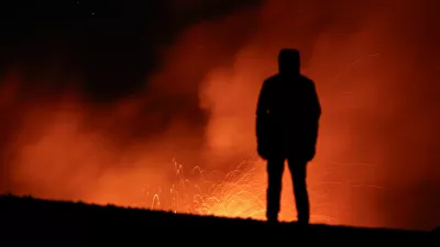 A person looks on as smoke and lava rise from a crater of Mount Etna, Europe's most active volcano in Italy July 23, 2024. REUTERS/Etna Walk/Marco Restivo   TPX IMAGES OF THE DAY