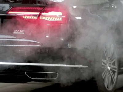 FILE - A luxury Audi car is surrounded by exhaust gases as it is parked with a running engine in front of the Chancellery in Berlin, Germany, Wednesday, Nov. 20, 2019. Germany's transport minister said Tuesday that his country won't back a planned European Union ban on the sale of new cars with combustion engines from 2035. (AP Photo/Michael Sohn, File)