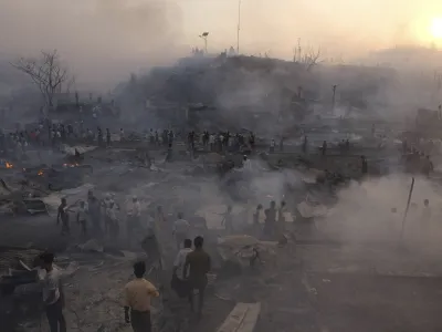 Rohingya refugees try to salvage their belongings after a major fire in their Balukhali camp at Ukhiya in Cox's Bazar district, Bangladesh, Sunday, March 5, 2023. A massive fire raced through a crammed camp of Rohingya refugees in southern Bangladesh on Sunday, leaving thousands homeless, a fire official and the United Nations said. (AP Photo/Mahmud Hossain Opu)