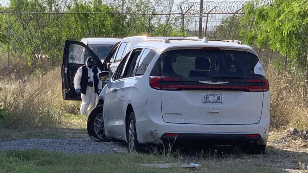 A Mexican police investigator inspects the minivan were four Americans where shot and taken from last week, at the Tamaulipas State prosecutor headquarters in Matamoros, Mexico, Wednesday, March 8, 2023. Their minivan crashed and was fired on shortly after they crossed into the border city of Matamoros on Friday as drug cartel factions tore through the streets, the region's governor said. A stray bullet also killed a Mexican woman about a block and a half away. (AP Photo/STR)