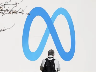 A person stands in front of a Meta sign outside of the company's headquarters in Menlo Park, Calif., Tuesday, March 7, 2023. Facebook's parent Meta will slash another 10,000 jobs and will not fill 5,000 open positions as the social media pioneer cuts costs. (AP Photo/Jeff Chiu)