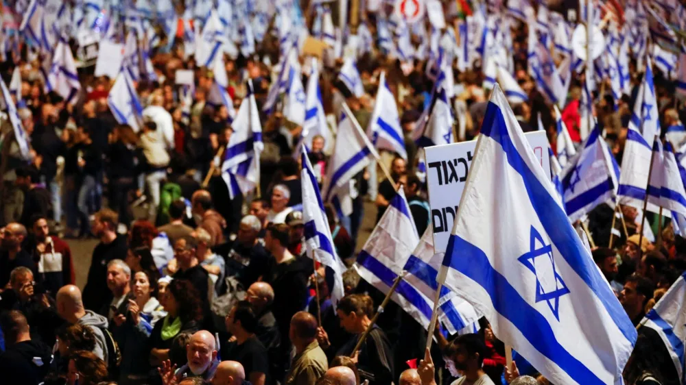 People hold Israeli flags during a demonstration as Israeli Prime Minister Benjamin Netanyahu's nationalist coalition government presses on with its contentious judicial overhaul, in Tel Aviv, Israel, March 11, 2023. REUTERS/Nir Elias