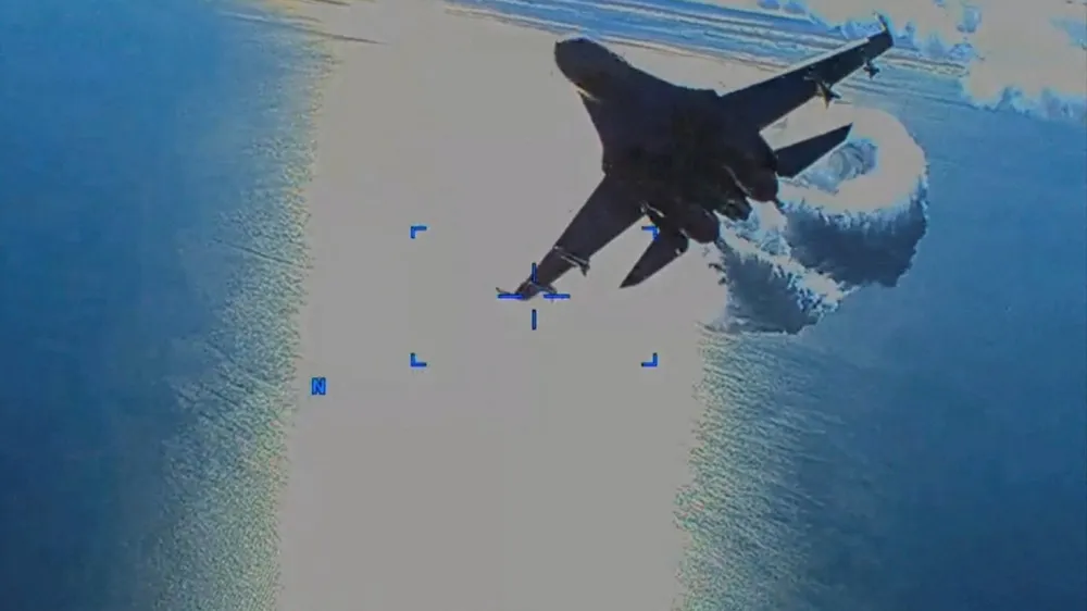 A Russian Su-27 military aircraft dumps fuel while flying by a U.S. Air Force MQ-9 "Reaper" drone over the Black Sea, March 14, 2023 in this still image taken from handout video released by the Pentagon. Courtesy of U.S. European Command/The Pentagon/Handout via REUTERS THIS IMAGE HAS BEEN SUPPLIED BY A THIRD PARTY. MANDATORY CREDIT.