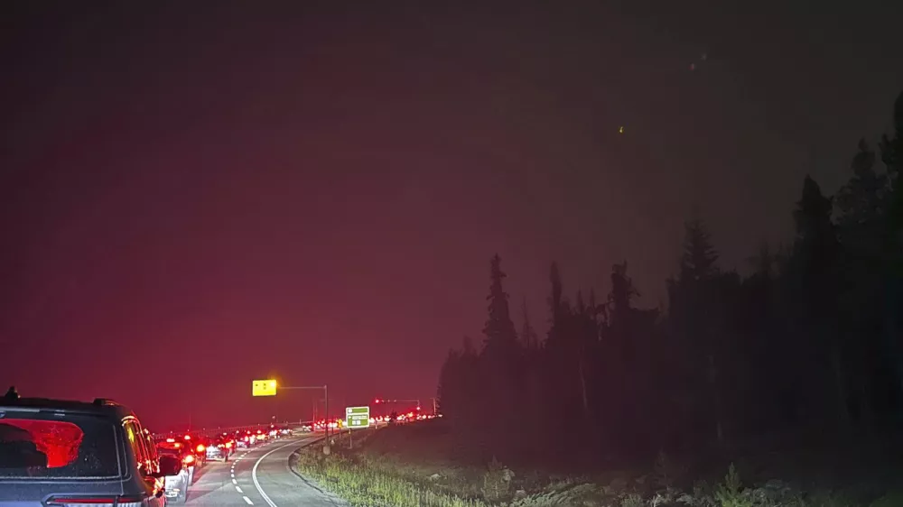 This photo provided by Carolyn Campbell shows cars clogging the highway as people evacuate because of wildfires early Tuesday, July 23, 2024, in Jasper, Alberta. Multiple wildfires in Canada's Jasper National Park have flared up, forcing all park visitors along with the 4,700 residents of the Jasper townsite to flee. (Carolyn Campbell/The Canadian Press via AP)