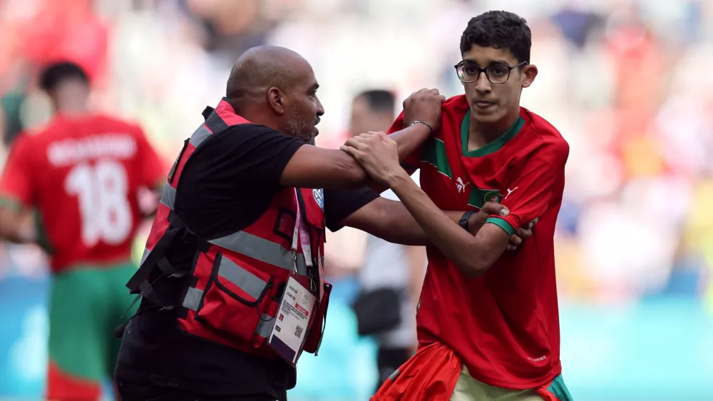 Paris 2024 Olympics - Football - Men's Group B - Argentina vs Morocco - Geoffroy-Guichard Stadium, Saint-Etienne, France - July 24, 2024. Pitch invader is detained by a steward after the match. REUTERS/Thaier Al-Sudani