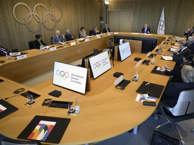 International Olympic Committee (IOC) President Thomas Bach, right up, speaks at the opening of the executive board meeting of the International Olympic Committee (IOC) in Lausanne, Switzerland, Tuesday, March 28, 2023. The IOC Executive Board is set to discuss the results of consultations regarding the status of athletes from Russia and Belarus in its meeting set to run until March 30. (Laurent Gillieron/Keystone via AP)