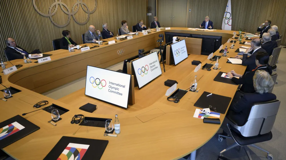 International Olympic Committee (IOC) President Thomas Bach, right up, speaks at the opening of the executive board meeting of the International Olympic Committee (IOC) in Lausanne, Switzerland, Tuesday, March 28, 2023. The IOC Executive Board is set to discuss the results of consultations regarding the status of athletes from Russia and Belarus in its meeting set to run until March 30. (Laurent Gillieron/Keystone via AP)