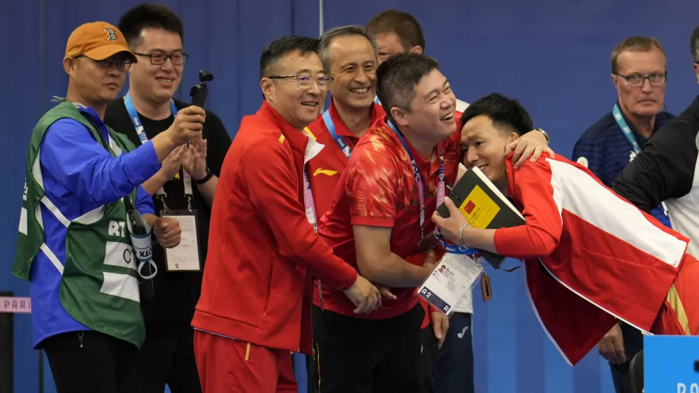 China's team celebrates after Huang Yuting and Sheng Lihao won the gold medal in the 10m air rifle mixed team competition at the 2024 Summer Olympics, Saturday, July 27, 2024, in Chateauroux, France. (AP Photo/Manish Swarup)