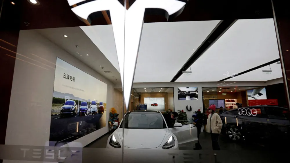 FILE PHOTO: Visitors check a Tesla Model 3 car next to a Model Y displayed at a showroom of the U.S. electric vehicle (EV) maker in Beijing, China February 4, 2023. REUTERS/Florence Lo/File Photo