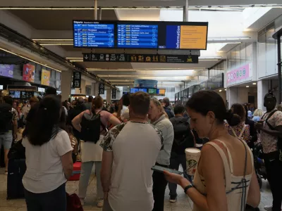 Travelers check trains on an electronic board at the Gare de Montparnasse, at the 2024 Summer Olympics, Friday, July 26, 2024, in Paris, France. Hours away from the grand opening ceremony of the Olympics, high-speed rail traffic to the French capital was severely disrupted on Friday following what officials described as "criminal actions" and sabotage. (AP Photo/Yasin Dar)