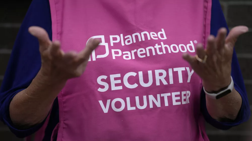 A Planned Parenthood clinic patient escort stands outside the building Thursday, July 18, 2024, in Ames, Iowa. (AP Photo/Charlie Neibergall)