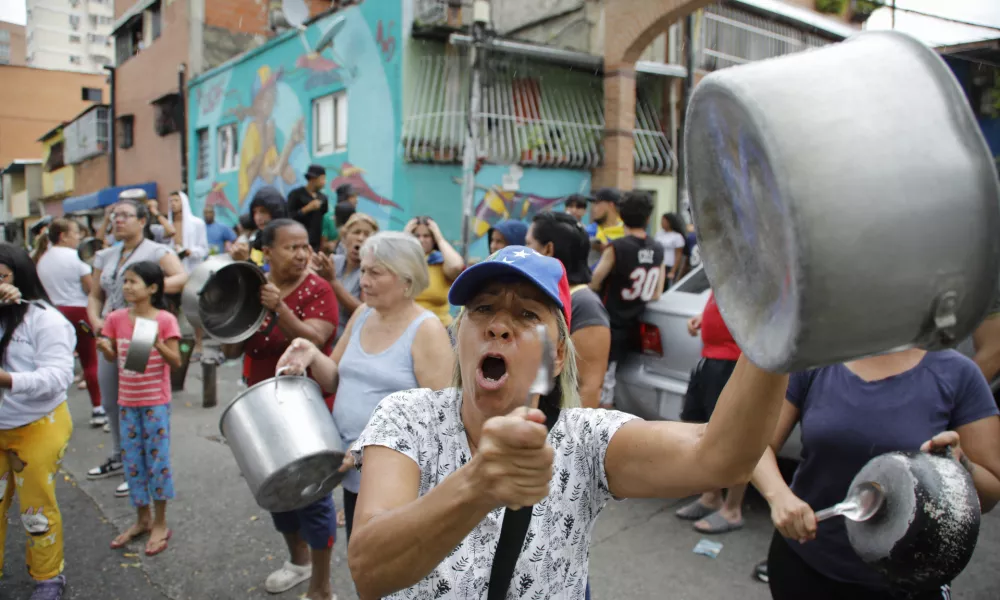 Residents bang pots to protest the day after the presidential election in Caracas, Venezuela, Monday, July 29, 2024. (AP Photo/Cristian Hernandez)