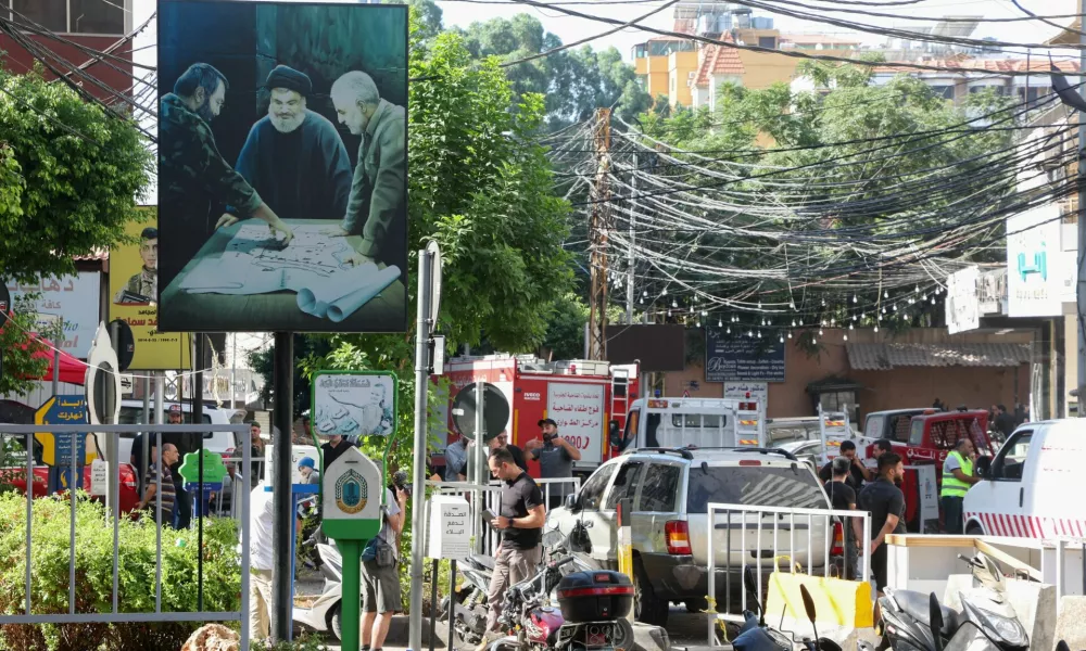 A poster depicting Lebanon's Hezbollah leader Sayyed Hassan Nasrallah, late top commander of Iran's Quds Force Qassem Soleimani and the late Hezbollah military commander Imad Moughniyeh, is pictured near a damaged site, the day after an Israeli strike, in Beirut's southern suburbs, Lebanon July 31, 2024. REUTERS/Mohamed Azakir