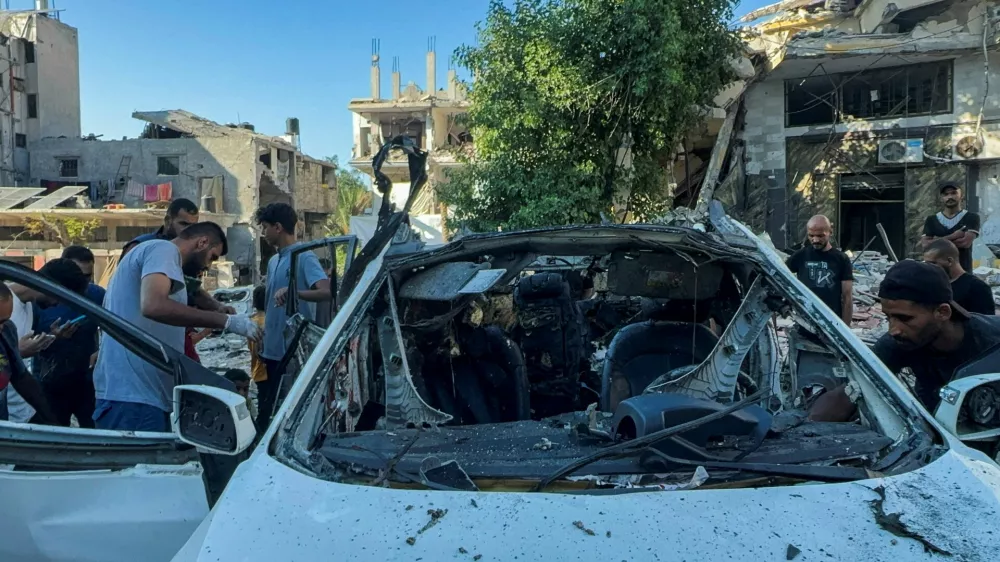 Palestinians inspect a vehicle where Al Jazeera TV said its reporter Ismail al-Ghoul and cameraman Ramy El Rify were killed in an Israeli strike, in Gaza City July 31, 2024. REUTERS/Ayman Al Hassi   TPX IMAGES OF THE DAY