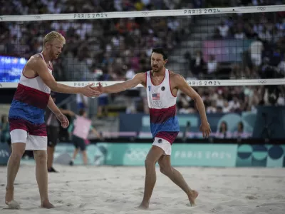 US' Chase Budinger, left, and Miles Evans react during the men's pool F beach volleyball match between Netherlands and USA at Eiffel Tower Stadium at the 2024 Summer Olympics, Tuesday, July 30, 2024, in Paris, France. (AP Photo/Louise Delmotte)