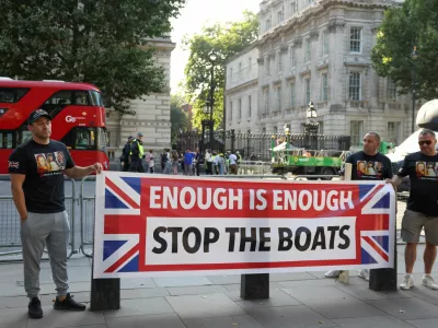 People hold a banner on the day of a protest against illegal immigration outside of Downing Street in London Britain, July 31, 2024. REUTERS/Hollie Adams