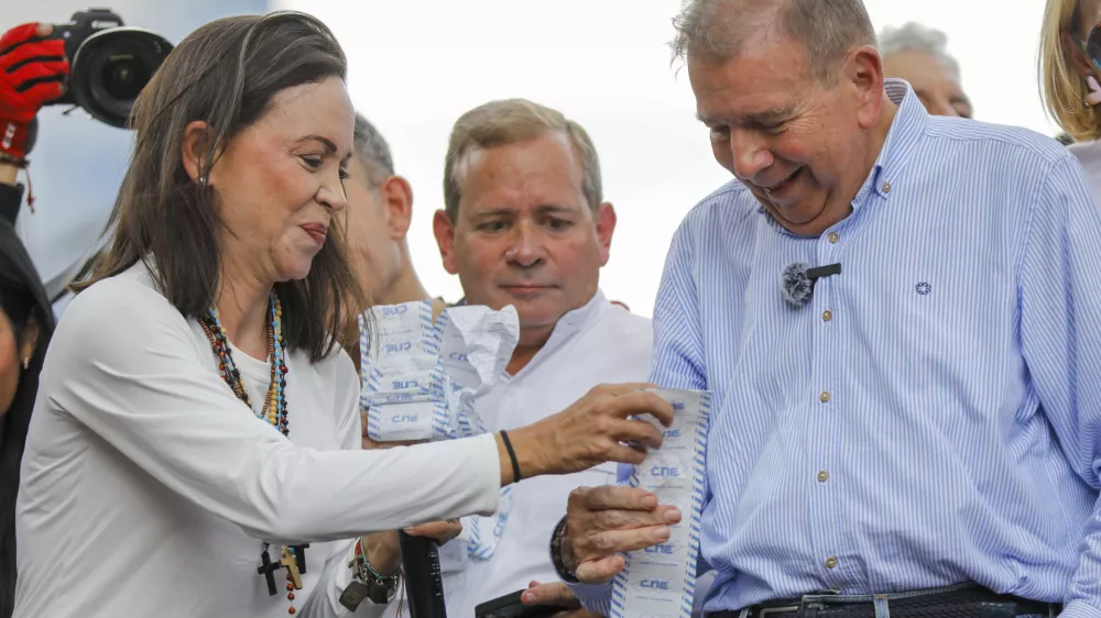 Opposition leader Maria Corina Machado, left, and opposition candidate Edmundo Gonzalez hold up vote tally sheets on the top of a truck during a protest against the official presidential election results declaring President Nicolas Maduro the winner in Caracas, Venezuela, on Tuesday, July 30, 2024, two days after the election. (AP Photo/Cristian Hernandez)