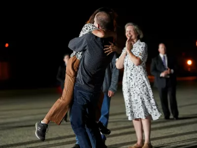 U.S. journalist Evan Gershkovich, who was released from detention in Russia, embraces his mother Ella Milman, as Ex-U.S. Marine Paul Whelan and his sister, Elizabeth Whelan, look on, at Joint Base Andrews in Maryland, U.S., August 1, 2024. REUTERS/Nathan Howard