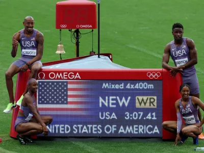 Paris 2024 Olympics - Athletics - 4 x 400m Relay Mixed Round 1 - Stade de France, Saint-Denis, France - August 02, 2024. Kaylyn Brown of United States, Bryce Deadmon of United States, Shamier Little of United States and Vernon Norwood of United States pose with a time board as they celebrate after setting a new world record and winning heat 1. REUTERS/Phil Noble