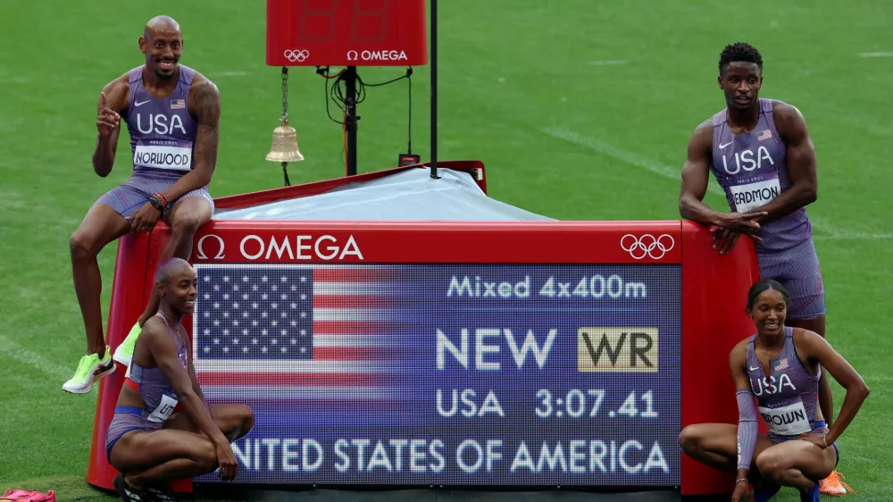 Paris 2024 Olympics - Athletics - 4 x 400m Relay Mixed Round 1 - Stade de France, Saint-Denis, France - August 02, 2024. Kaylyn Brown of United States, Bryce Deadmon of United States, Shamier Little of United States and Vernon Norwood of United States pose with a time board as they celebrate after setting a new world record and winning heat 1. REUTERS/Phil Noble