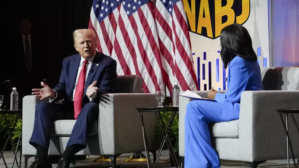 FILE - Republican presidential candidate former President Donald Trump, left, moderated by ABC's Rachel Scott, speaks at the National Association of Black Journalists convention, July 31, 2024, in Chicago. The backlash against Trump's attack on Vice President Kamala Harris' racial identity intensified on Thursday. Democrats expressed new outrage and some Republicans distanced themselves from Trump's comments that Harris only recently "turned Black" for political gain. Harris is of Jamaican and Indian heritage. Trump shrugged off the criticism and doubled down by posting on social media a new picture depicting Harris in traditional Indian garb. (AP Photo/Charles Rex Arbogast, File)