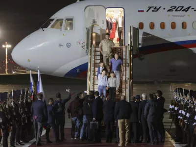 Russian President Vladimir Putin, center back to a camera, greets released Russian prisoners upon their arrival at the Vnukovo government airport outside Moscow, Russia, on Thursday, Aug. 1, 2024. The United States and Russia have made their biggest prisoner swap in post-Soviet history. (Gavriil Grigorov/Sputnik, Kremlin Pool Photo via AP)