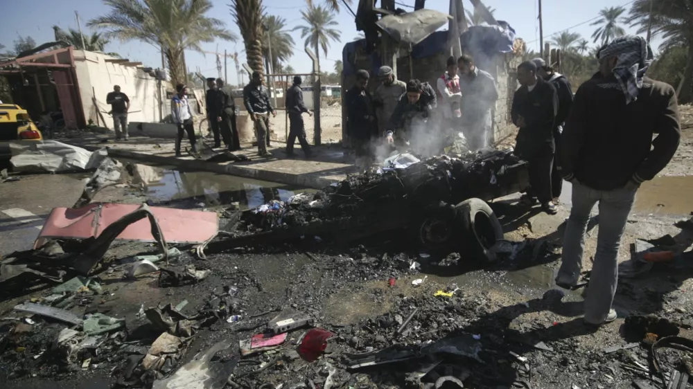 Residents gather at the site of a bomb attack in Kerbala, 110 km (70 miles) south of Baghdad, March 20, 2012. At least 16 near-simultaneous explosions struck cities and towns across Iraq on Tuesday, killing at least 43 people and wounding more than 200, despite a massive security clampdown ahead of next week's Arab League summit. REUTERS/Mushtaq Muhammed (IRAQ - Tags: CONFLICT POLITICS CIVIL UNREST)