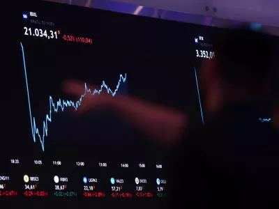 A person points to an electronic board displaying information of recent fluctuations of market indices at the B3 Stock Exchange in Sao Paulo, Brazil August 5, 2024. REUTERS/Carla Carniel