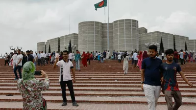 People take pictures in front of the parliament building, a day after the resignation of Bangladeshi Prime Minister Sheikh Hasina, in Dhaka, Bangladesh, August 6, 2024. REUTERS/Mohammad Ponir Hossain