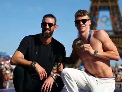 Paris 2024 Olympics - Champions Park medallists celebrations - Champions Park, Paris, France - August 06, 2024. Swimming gold medallist Leon Marchand of France poses with former United states Olympic champion swimmer Michael Phelps during the Champions Park medallists celebrations in front of the Eiffel Tower. REUTERS/Tingshu Wang