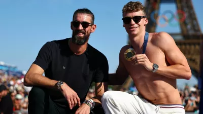 Paris 2024 Olympics - Champions Park medallists celebrations - Champions Park, Paris, France - August 06, 2024. Swimming gold medallist Leon Marchand of France poses with former United states Olympic champion swimmer Michael Phelps during the Champions Park medallists celebrations in front of the Eiffel Tower. REUTERS/Tingshu Wang