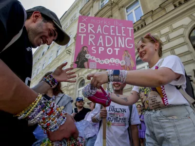 Swifties trade bracelets in the city centre in Vienna on Thursday, Aug.8, 2024. Organizers of three Taylor Swift concerts in the stadium in Vienna this week called them off on Wednesday after officials announced arrests over an apparent plot to launch an attack on an event in the Vienna area such as the concerts. (AP Photo/Heinz-Peter Bader)