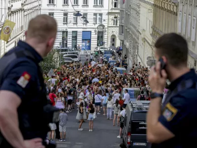 Austrian police officers watch swifts gathering in the city centre in Vienna on Thursday, Aug.8, 2024. Organizers of three Taylor Swift concerts in the stadium in Vienna this week called them off on Wednesday after officials announced arrests over an apparent plot to launch an attack on an event in the Vienna area such as the concerts. (AP Photo/Heinz-Peter Bader)