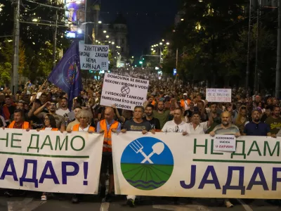 People hold banners reading, "We Won't Give up Jadar!" and march during a protest against pollution and the exploitation of a lithium mine in the country in Belgrade, Serbia, Saturday, Aug. 10, 2024. Jadar is a farming valley in western Serbia that holds one of Europe's richest deposits of lithium. (AP Photo/Darko Vojinovic)