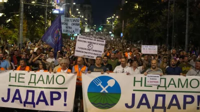 People hold banners reading, "We Won't Give up Jadar!" and march during a protest against pollution and the exploitation of a lithium mine in the country in Belgrade, Serbia, Saturday, Aug. 10, 2024. Jadar is a farming valley in western Serbia that holds one of Europe's richest deposits of lithium. (AP Photo/Darko Vojinovic)