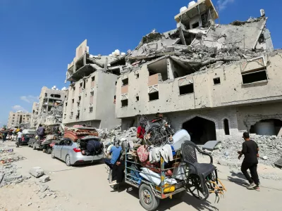 Displaced Palestinians make their way as they flee Hamad City following an Israeli evacuation order, amid Israel-Hamas conflict, in Khan Younis in the southern Gaza Strip August 11, 2024. REUTERS/Hatem Khaled   TPX IMAGES OF THE DAY