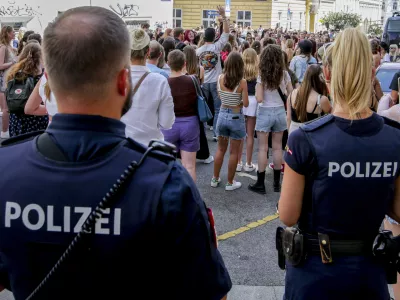 Police officers stand near gathering swifties in Vienna on Friday, Aug.9, 2024. Organizers of three Taylor Swift concerts in the stadium in Vienna this week called them off on Wednesday after officials announced arrests over an apparent plot to launch an attack on an event in the Vienna area such as the concerts. (AP Photo/Heinz-Peter Bader)