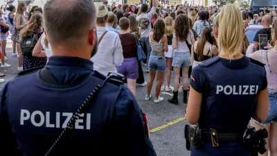 Police officers stand near gathering swifties in Vienna on Friday, Aug.9, 2024. Organizers of three Taylor Swift concerts in the stadium in Vienna this week called them off on Wednesday after officials announced arrests over an apparent plot to launch an attack on an event in the Vienna area such as the concerts. (AP Photo/Heinz-Peter Bader)