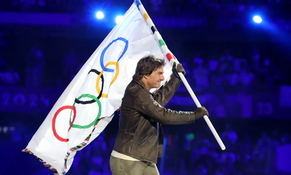 Paris 2024 Olympics - Ceremonies - Paris 2024 Closing Ceremony - Stade de France, Saint-Denis, France - August 11, 2024. Actor Tom Cruise holds the Olympic flag during the closing ceremony. REUTERS/Phil Noble