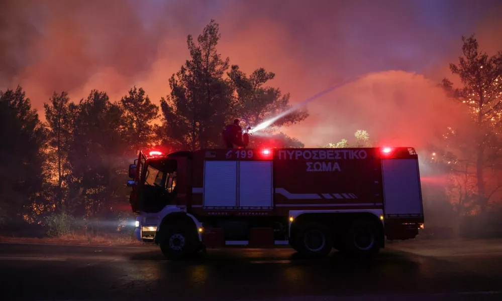 A firefighter tries to extinguish a wildfire burning in Dionysos, Greece, August 12, 2024. REUTERS/Alexandros Avramidis