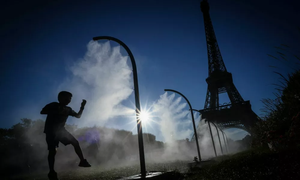 A boy plays under a spray of cooling water on a hot day outside the Eiffel Tower Stadium during the 2024 Olympics in Paris, France, July 28, 2024. REUTERS/Esa Alexander   "OLYMPIC BEHIND THE SCENES" FOR THIS STORY. SEARCH "OLYMPIC SIDELINES" FOR ALL STORIES.