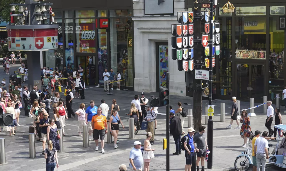 Police cordon off an area in Leicester Square, as a man was arrested with the accusation of stabbing an 11-year-old girl and 34-year-old woman, in London, Monday Aug. 12, 2024. (James Manning/PA via AP)