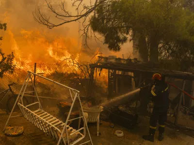 12 August 2024, Greece, Athens: A firefighter extinguishes a large fire, just a few kilometers northeast of Athens. EU member states are sending aid to Greece to help emergency services in battling the country's biggest wildfire of the year on Monday, with multiple flash points burning across some 200 square kilometres of woodland north-east of the capital Athens. Photo: Socrates Baltagiannis/dpa