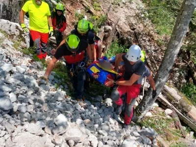 Med transportom pokojnika po strmem in zahtevnem gozdnem terenu je na enega od reševalcev padla skala in ga hudo poškodovala. Foto: GRS Kamnik