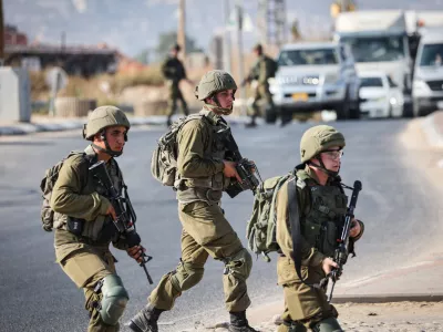 FILED - 19 August 2023, Palestinian Territories, Huwara: Israeli soldiers block a road in the West Bank. Photo: Ilia Yefimovich/dpa