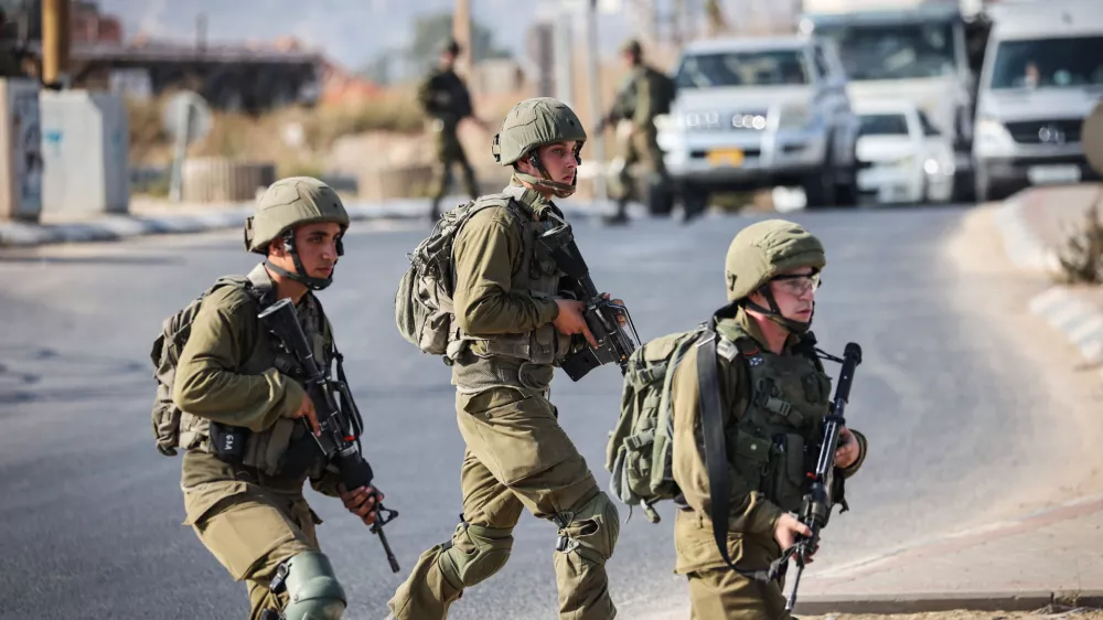 FILED - 19 August 2023, Palestinian Territories, Huwara: Israeli soldiers block a road in the West Bank. Photo: Ilia Yefimovich/dpa