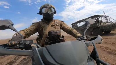 In this photo taken from video released by Russian Defense Ministry Press Service on Monday, Aug. 12, 2024, a marine assault team member rides motorcycle toward Ukrainian position at an undisclosed location. (Russian Defense Ministry Press Service photo via AP)